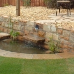 Water feature with paving  and  sandstone walling